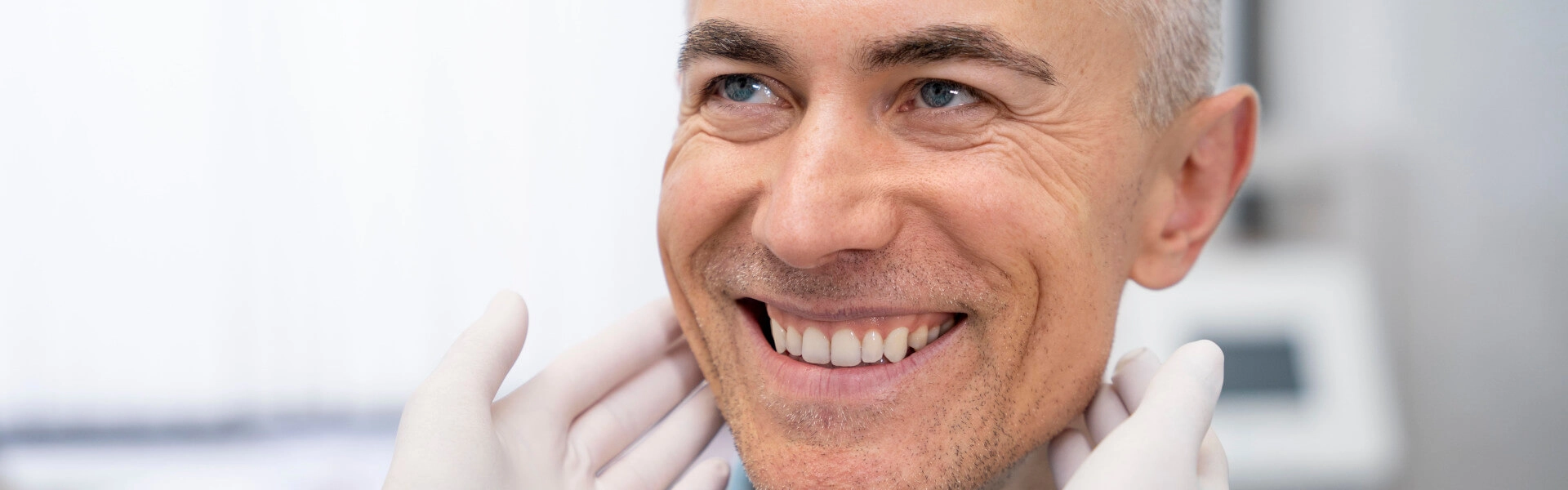 Lächelnder Mann bei zahnärztlicher Kontrolle für Zahngesundheit und professionelle Zahnreinigung.